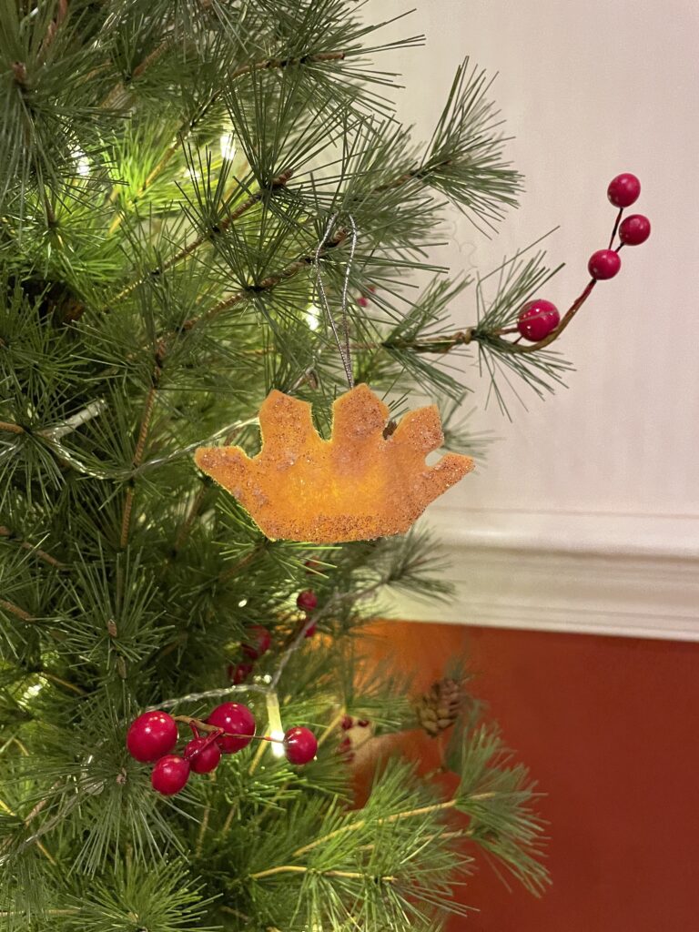 A felt shaped crown ornament on a tree is used as a symbol of King David