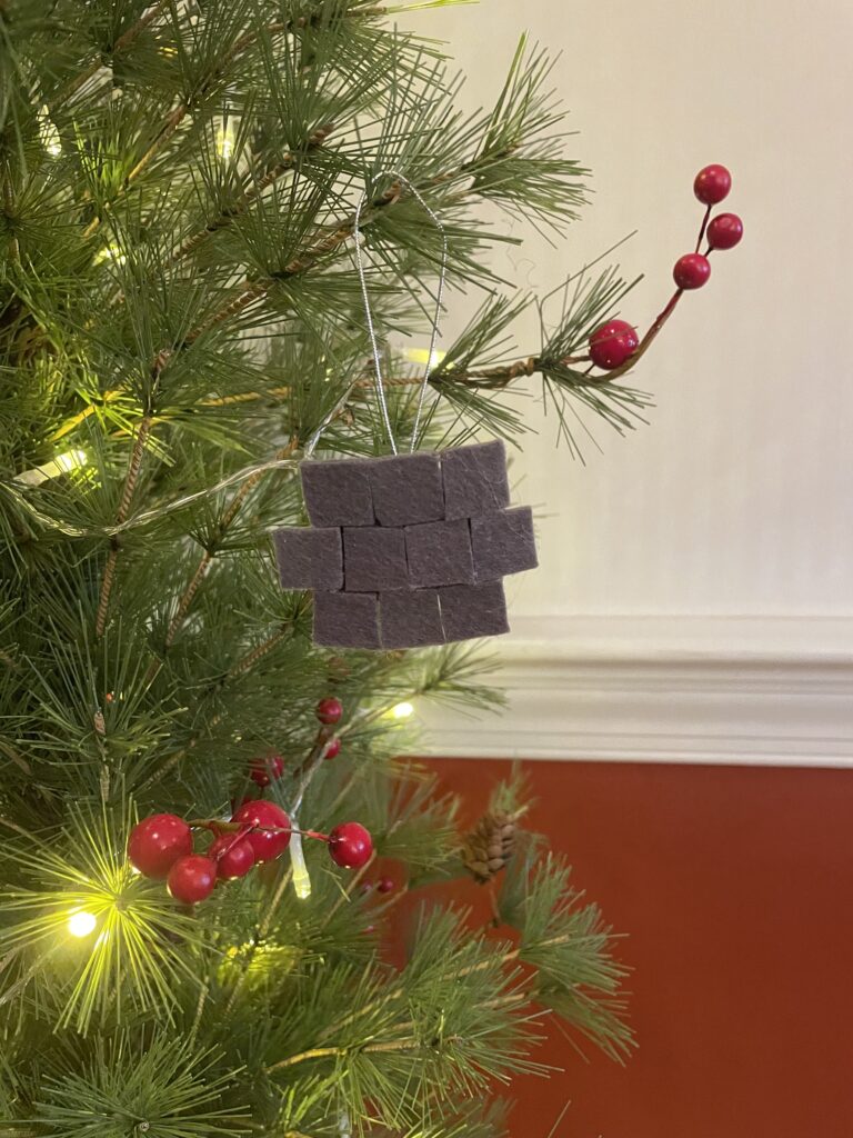 A wall ornament hanging from a Christmas tree.
