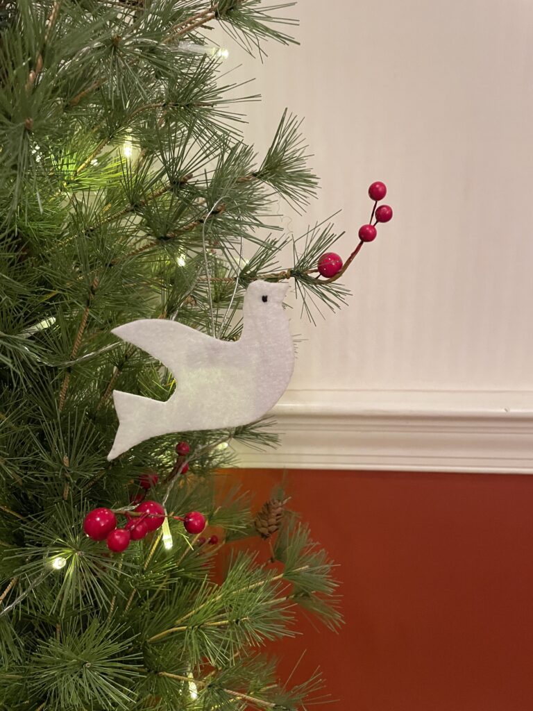 An Ornament Symbol of A Dove hanging on a Christmas tree to symbolize peace