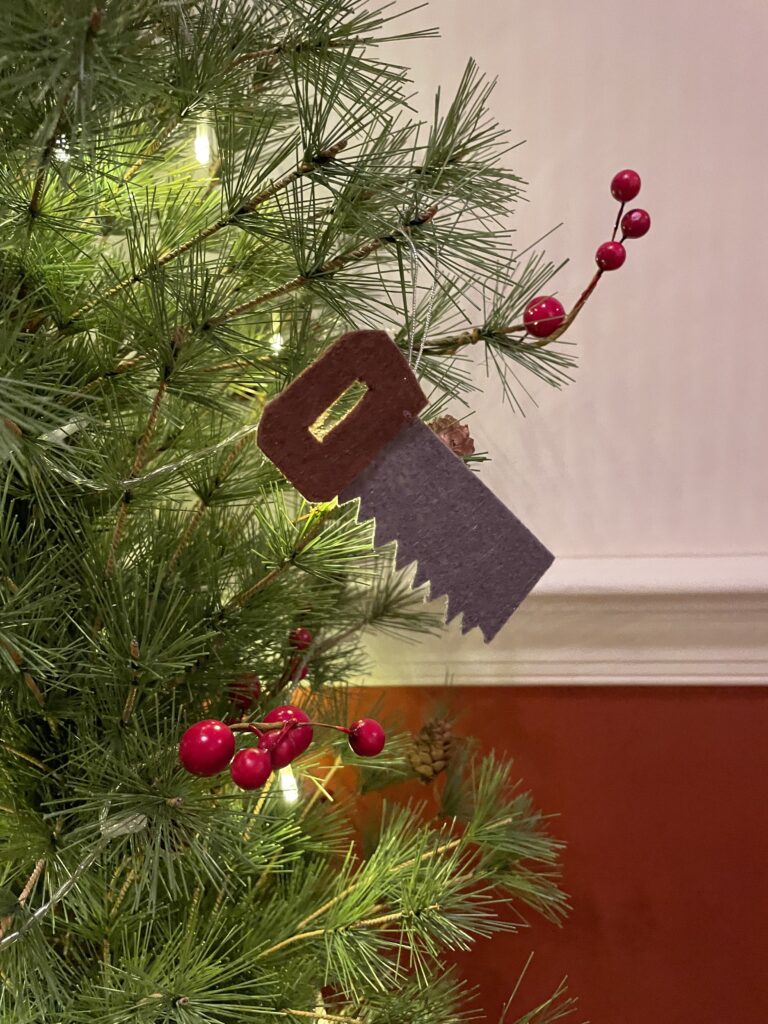 Ornament Symbol of A Handsaw hanging from a Christmas tree to depict Joseph the earthly father of Jesus.